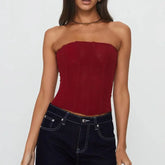 Woman wearing a strapless red top and dark jeans- close-up
